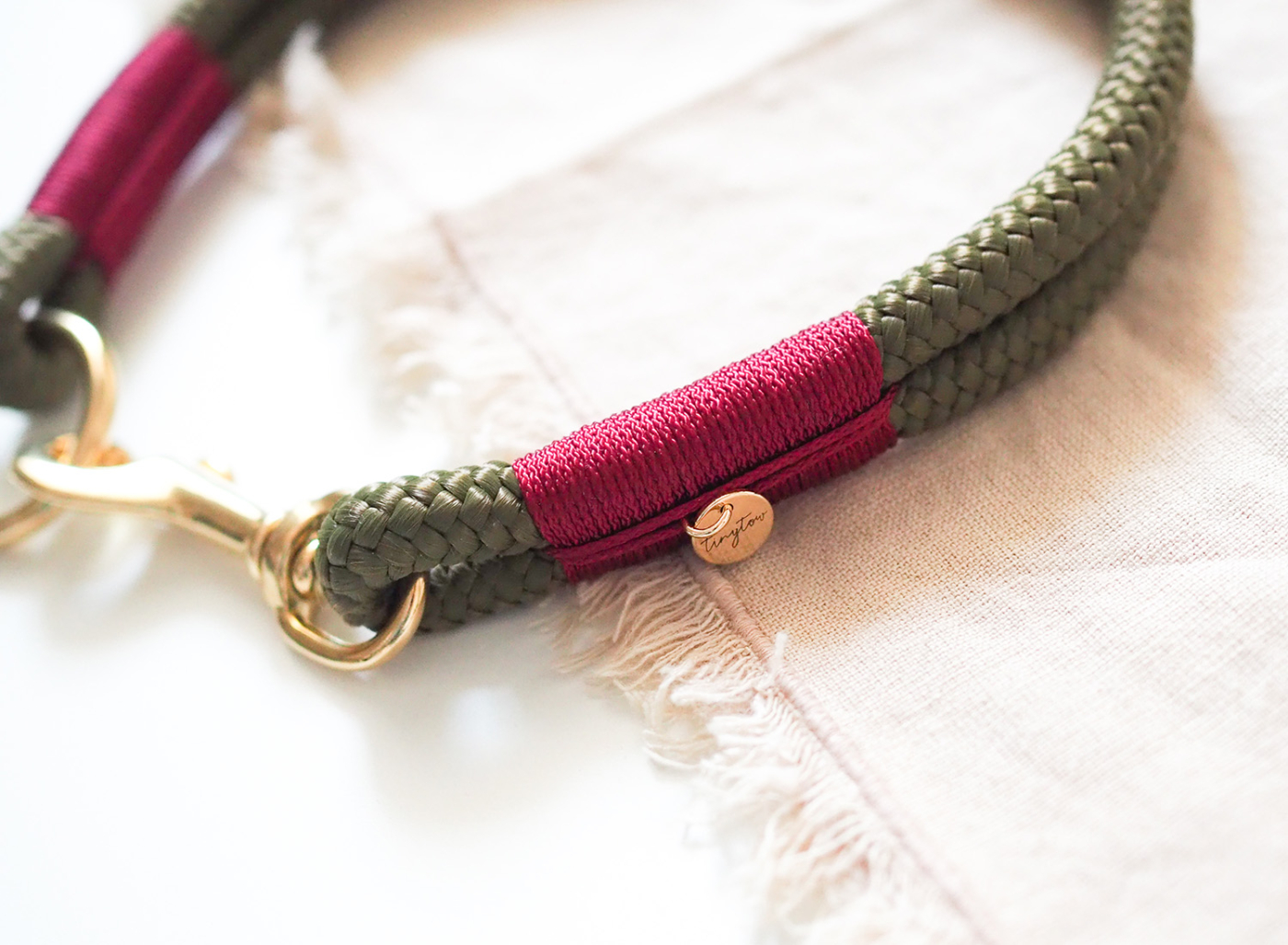 Nahaufnahme unseres Halsbandes aus Tau in 10mm in Olivgrün mit Weinroter Umwickelung und goldenen Details